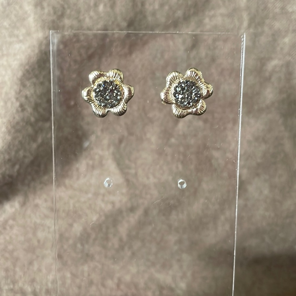 Flower shape earrings with grey tone crystal centers.
